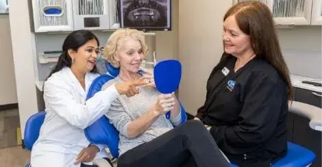 dental-patient-looking-at-mirror-with-dentist